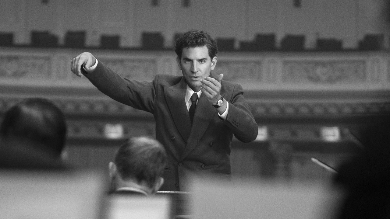 Bradley Cooper as Leonard Bernstein conducting an orchestra